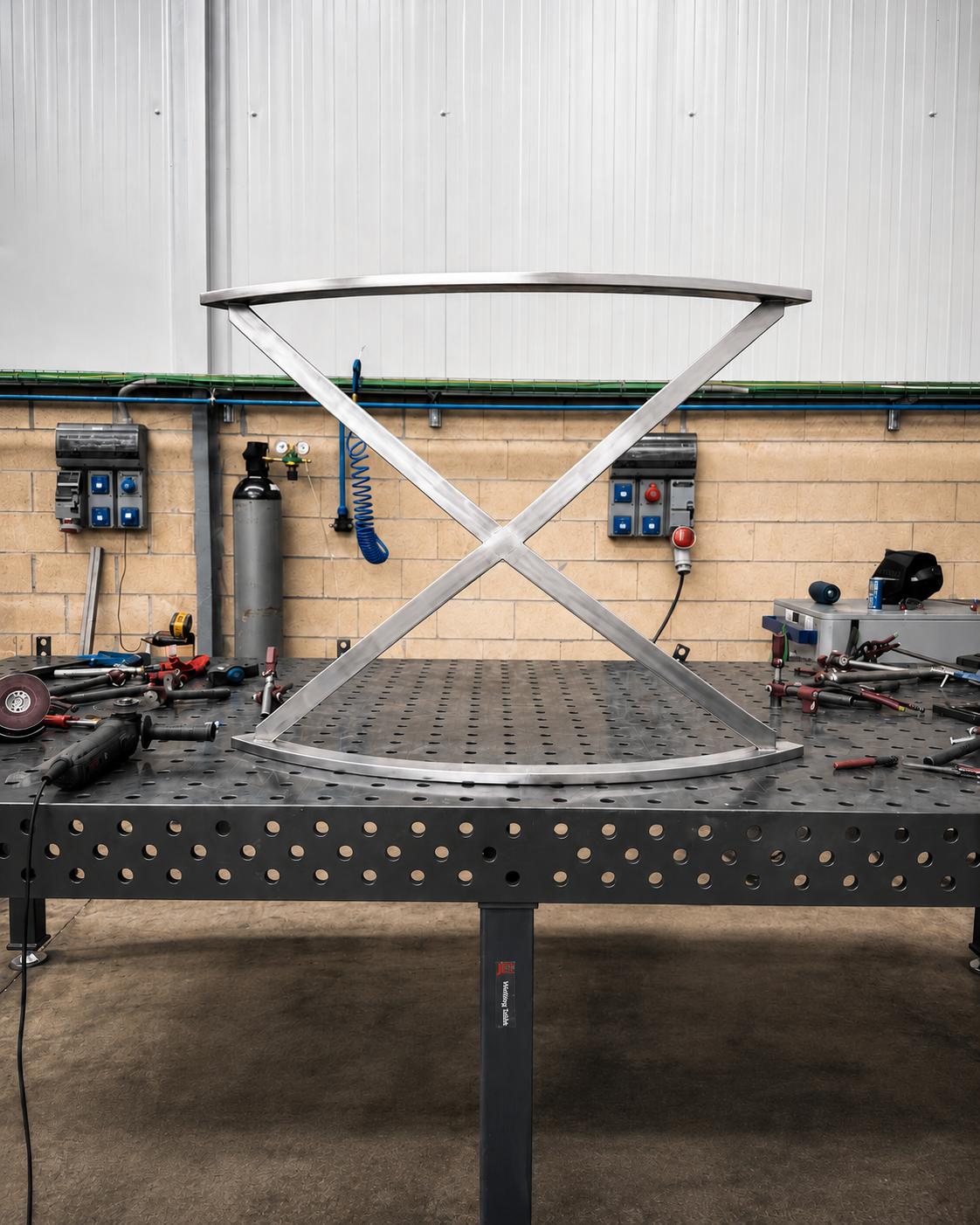 Estructura metálica curva fabricada a medida sobre mesa de trabajo